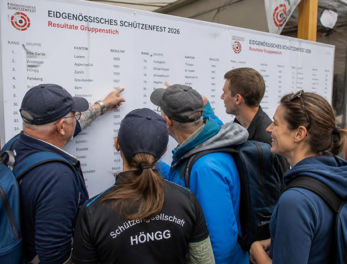 Schützen studieren die Ranglisten an der Resultattafel eines Schützenfests